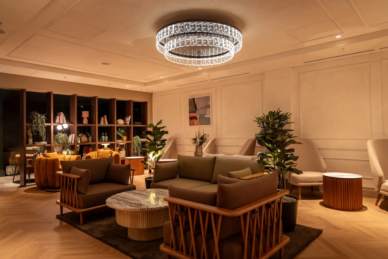 Interior of the No1 Lounge at Heathrow Terminal 2 with chandelier, sofas and curated bookshelf seating area